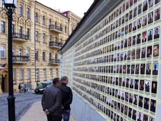 На Андреевском спуске повесили баннер с фотографиями погибших военных